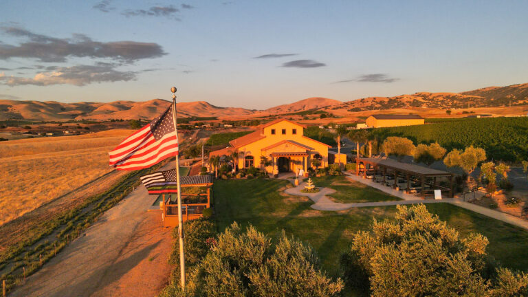 McGrail Vineyards estate overlooking Livermore Valley at sunset with an American flag flying above the vineyard.